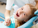 Photo of girl in getting a checkup in dentist chair.