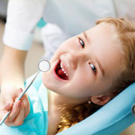 Photo of girl in getting a checkup in dentist chair.
